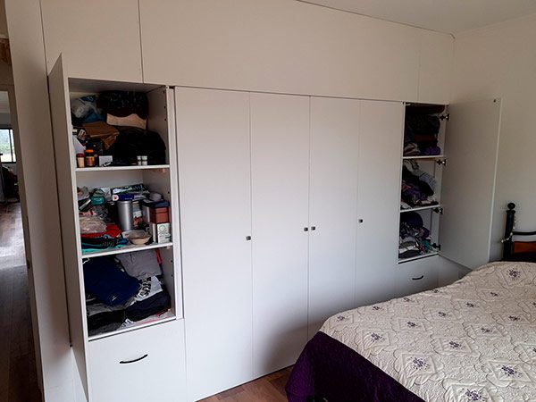 Interior closet muro a muro zona colgado doble estantes y cajones tiradores metálicos muebles a medida Santiago 2021