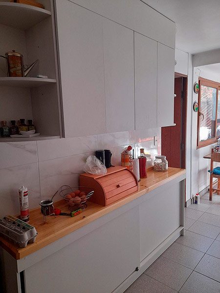 Detalle alacenas superiores y nicho estantería cocina a medida cubierta pino radiata barnizado fabricación mobiliario Santiago 2022