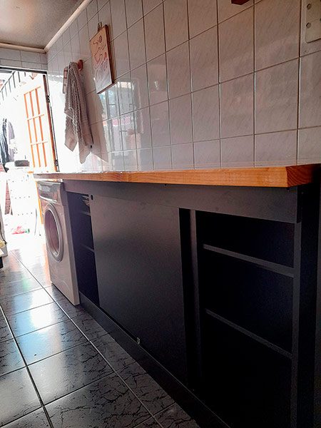Mueble bajo zona lavandería melamina negra cubierta pino radiata pulido espacio lavadora puertas corredizas muebles a medida Santiago 2020